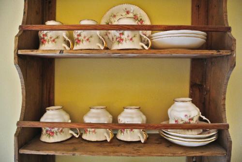 a wooden shelf with dishes and vases on it at Krivine B&B in Midreshet Ben Gurion