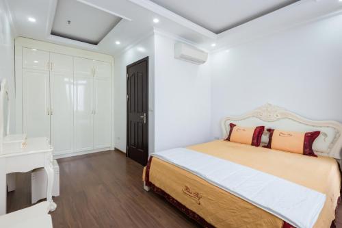a bedroom with a bed and a dresser at The Peninsula Haiphong in Hai Phong