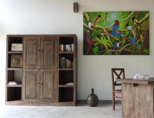 una habitación con una estantería de libros y una pintura en la pared en Ambarella Lodge - Katunayake, en Hunumulla