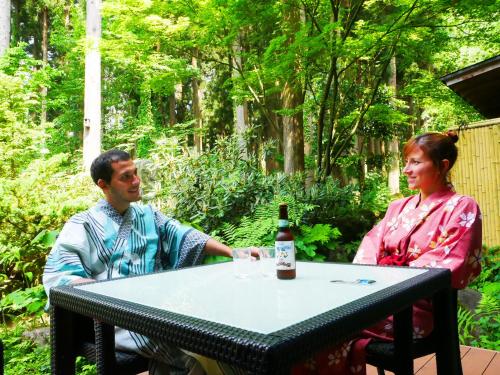 a man and woman sitting at a table with a bottle of wine at Ichirino Kogen Hotel Roan in Hakusan