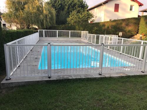 une clôture blanche autour d'une piscine dans l'établissement Clos ETCHBERRI, à Bidart