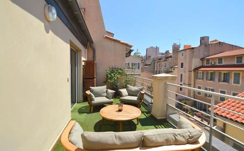 a patio with a table and chairs on a balcony at Les Appartements du Vieux Port in Marseille