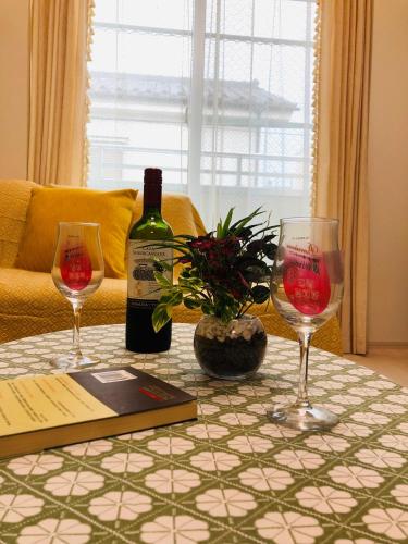 a table with two wine glasses and a bottle of wine at Takara House in Tokyo