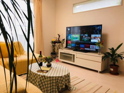 a living room with a flat screen tv at Takara House in Tokyo