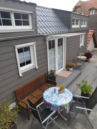 a patio with a wooden bench and a table and chairs at Tinyhaus Wolkenlos Familie Hamdorf in Bad Sulza