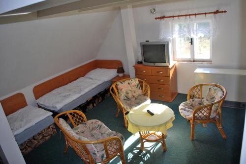 Cette chambre comprend deux lits, une table et des chaises. dans l'établissement Penzion Na Staré Cestě, à Deštné v Orlických horách