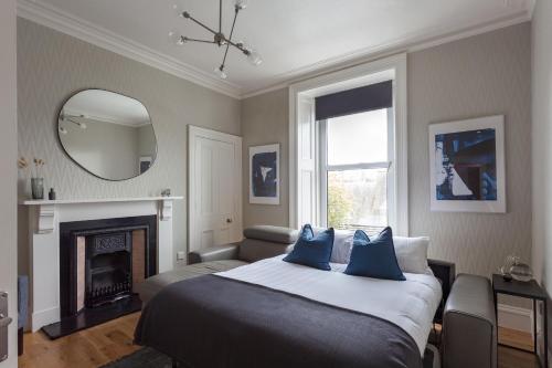 a bedroom with a bed with a mirror and a fireplace at Esslemont Pad in Aberdeen