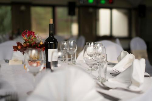 a table with a bottle of wine and wine glasses at Park Villa Hotel in Vilnius