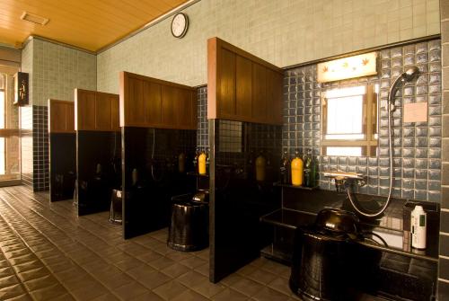 a kitchen with a sink and a clock on the wall at Dormy Inn Premium Shimonoseki in Shimonoseki