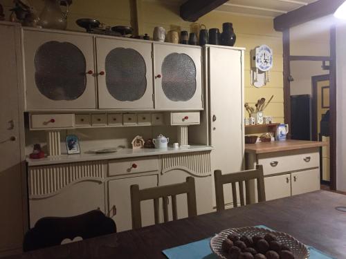a kitchen with white cabinets and a table with chairs at Chalupa Janov nad Nisou 1064 in Janov nad Nisou