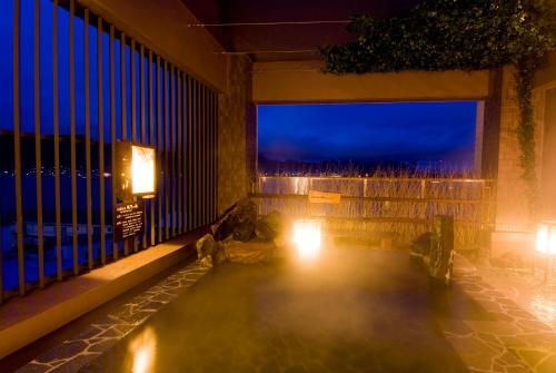 a room with a view of the ocean at night at Dormy Inn Premium Shimonoseki in Shimonoseki