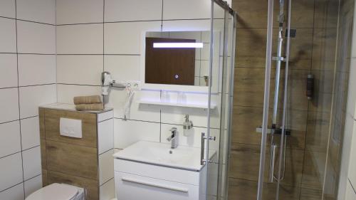 a bathroom with a toilet and a sink and a shower at Hotel Glas Schwarzwald in Fluorn