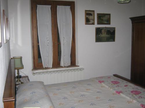 a bedroom with a bed and a window at Agriturismo Santa Maria in Torrita di Siena
