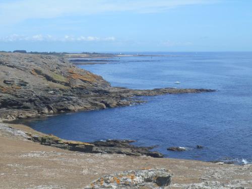 a large body of water with rocks and the ocean at Les pieds dans l eau in Larmor-Plage