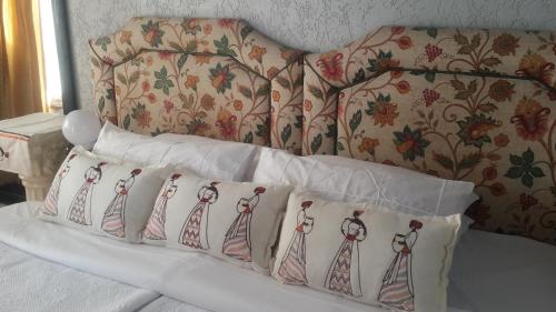 a bed with four pillows on top of it at Madida's Bed and Breakfast in Soweto