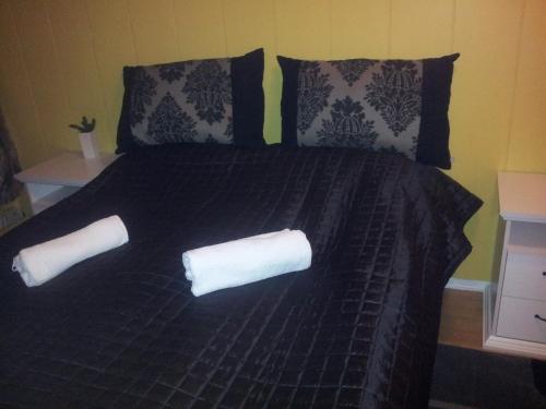 a black bed with two white pillows on it at Barents Hotell in Kirkenes