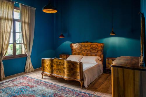 a bedroom with blue walls and a bed and a window at Castello di Lispida in Monselice