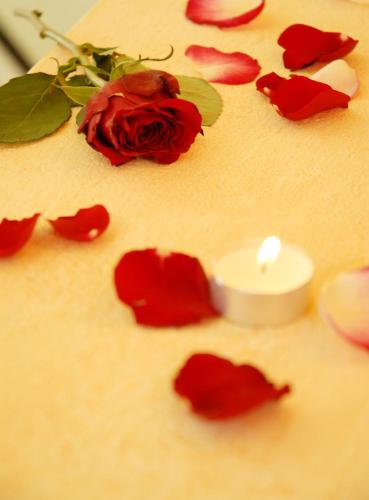 a candle sitting on a table with red roses at Aparthotel Sunrise in Ramsau am Dachstein