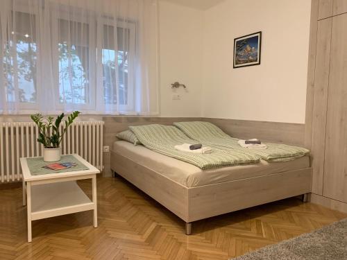 um quarto com uma cama, uma mesa e uma janela em Heroes’ Residence II em Budapeste