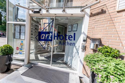 un cartel en la puerta de un agente de un hotel de arte en Art Hotel Aachen, en Aachen