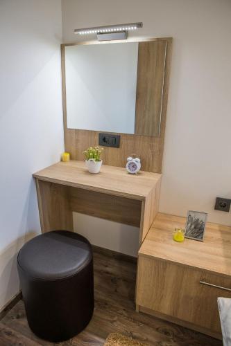 a vanity with a mirror and a stool in a room at Apartmani Petra i Tea in Krapina