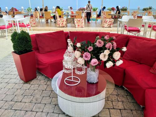a red couch with a table with flowers on it at Shalanda in Odesa
