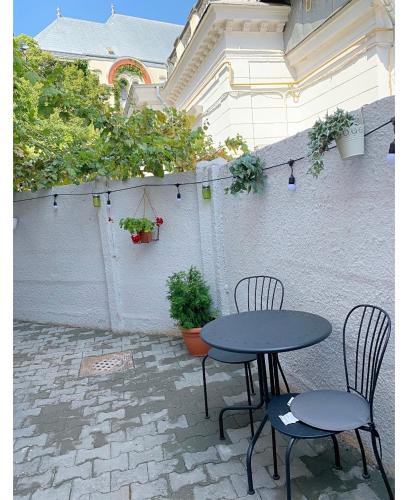 a patio with two tables and chairs and plants at Maison 33 in Bucharest
