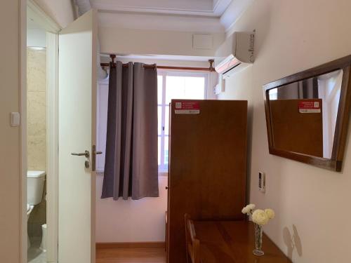 a bathroom with a mirror, sink, and toilet at Residencial Lord in Lisbon