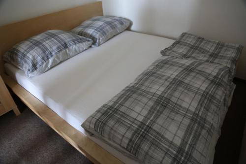 Una cama blanca con dos almohadas. en Praha 2, en Praga