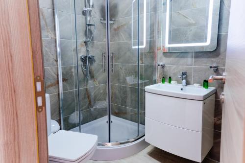 a bathroom with a shower and a toilet and a sink at Alezzi Beach Resort in Mamaia Nord