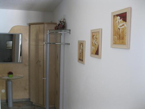 Cette chambre est dotée d'un mur blanc avec un réfrigérateur et des photos. dans l'établissement Appartement Geisler, à Zell am Ziller