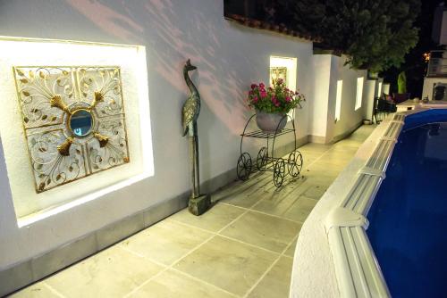 a statue of a bird on a wall next to a swimming pool at Vila Mila in Arandjelovac