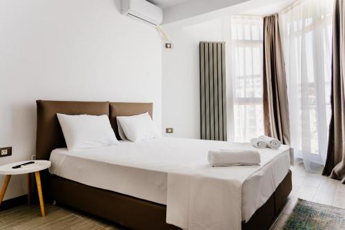 a bedroom with a large bed with white sheets at Alezzi Beach Resort in Mamaia Nord