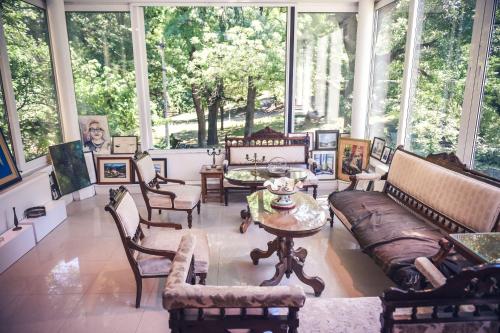 a living room with a lot of furniture and large windows at Vila Mila in Arandjelovac