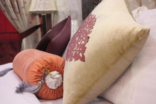 a pillow on a bed with pumpkins on it at Hotel The Leschanze in Lahore