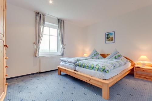 a bedroom with a wooden bed with blue pillows at Am Ostseestrand 1 in Zingst