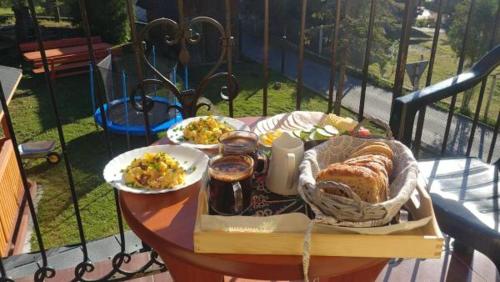 Una mesa con una bandeja de comida en un balcón. en Willa Babia Góra, en Zawoja