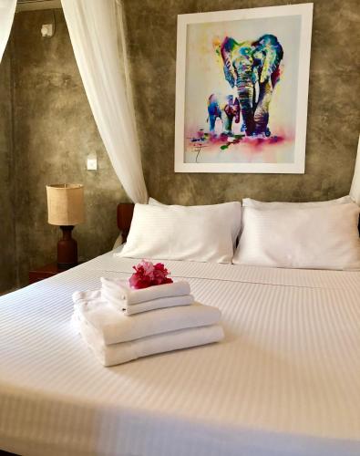 a pile of towels sitting on top of a bed at Amani Residence Beverly Suites in Malindi