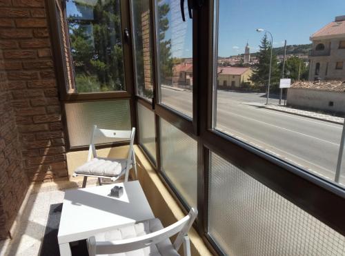 two white chairs sitting in front of a window at Vivienda uso turistico Atalaya in El Burgo de Osma