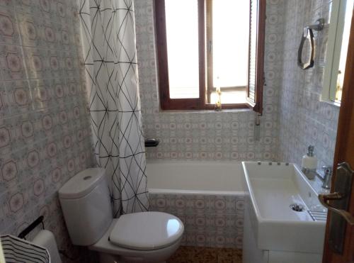 a bathroom with a toilet and a tub and a sink at Vivienda uso turistico Atalaya in El Burgo de Osma