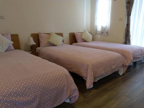 a bedroom with two beds and a window at Taroko Xincheng Old Street in Xincheng