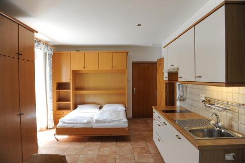 eine Küche mit einem Bett und einem Waschbecken darin in der Unterkunft Haus Schlossblick in Goldrain