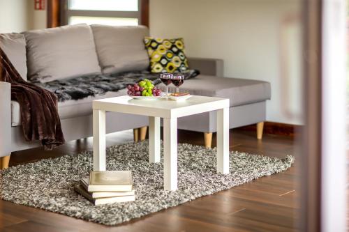a white coffee table in a living room with a couch at Bliżej Natury in Białowieża