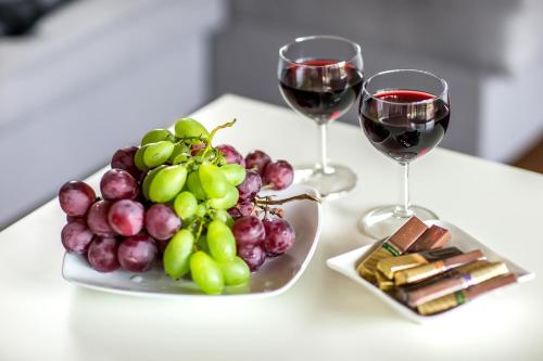 a plate of grapes and two glasses of wine at Bliżej Natury in Białowieża