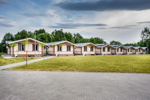 a row of houses with a grass field in front at Bliżej Natury in Białowieża