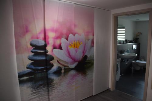 a bathroom with a painting of a pink flower on the wall at „Schönes“ Ferienhaus in Thale