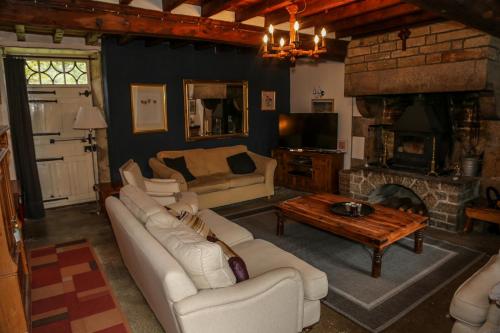 uma sala de estar com um sofá e uma lareira em La Maison du Chene em Percy