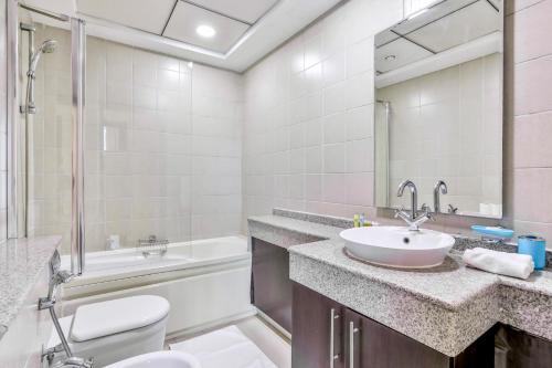 a bathroom with a sink and a tub and a toilet at 2BR High Floor Torch Tower Dubai Marina in Dubai