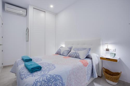 um quarto com uma cama com um cobertor azul e branco em ICEBERG LUXURY TARIFA ***** em Tarifa