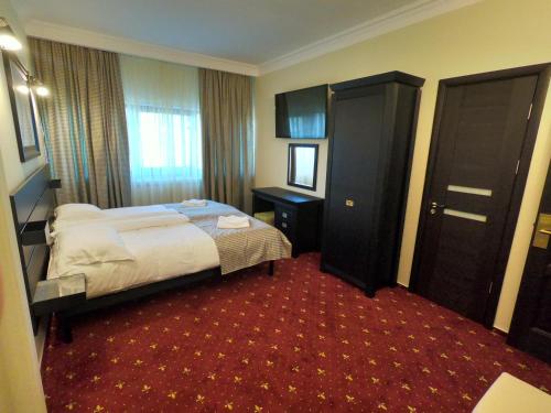 a hotel room with a bed and two doors at Casa Bucovineana in Suceava